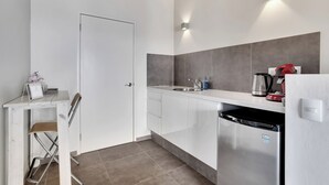A modern kitchen with white cabinets, a stainless steel refrigerator, a sink, and a countertop with a kettle and a red appliance. - All Seasons by Boutique Bonaire Unique Resorts (Kralendijk)