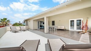 A spacious outdoor patio with a dining area, lounge chairs, and a hammock. - All Seasons by Boutique Bonaire Unique Resorts (Kralendijk)