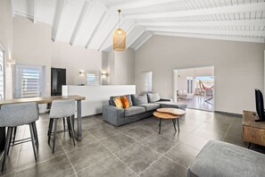 Un espacio de estar moderno con cocina, comedor y zona de descanso.