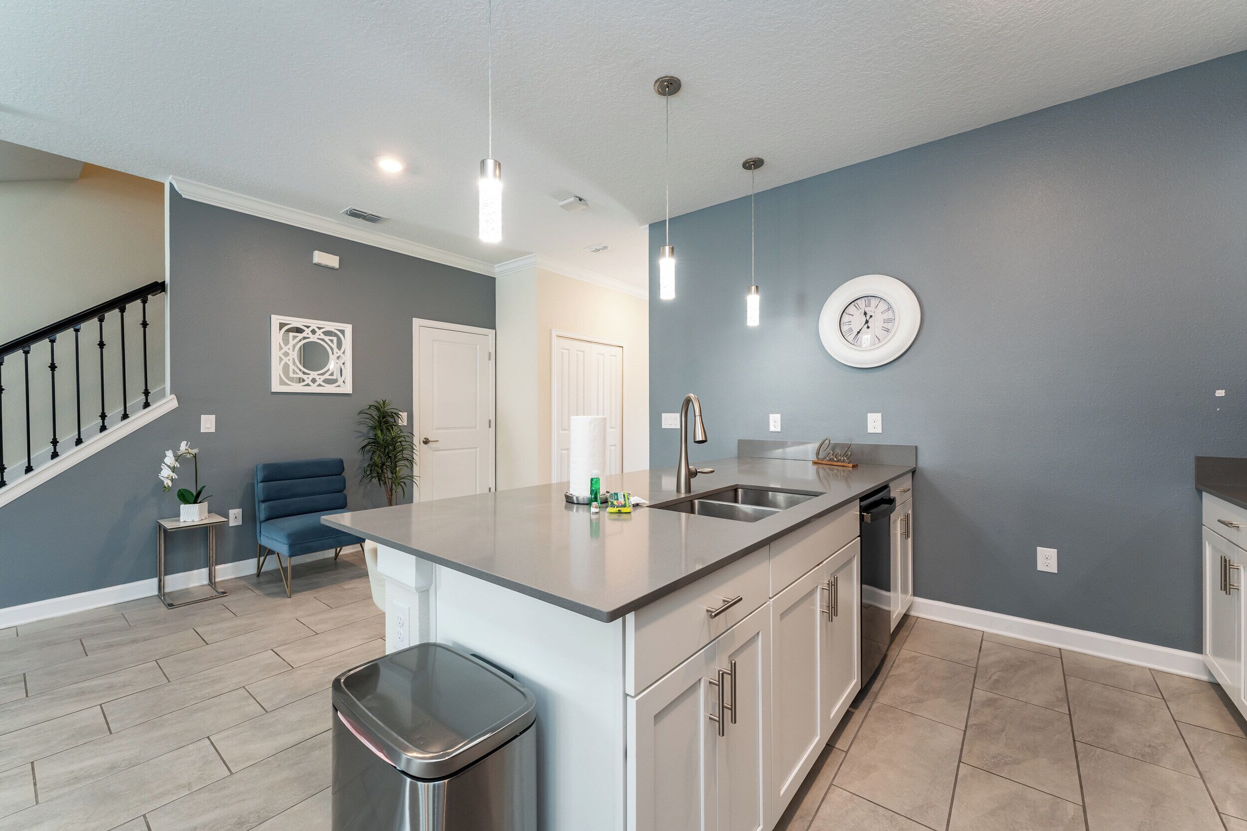 A modern kitchen with a central island, stainless steel appliances, and pendant lighting.