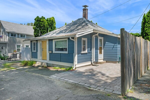 A small, single-story house with a gabled roof, a front porch, and a chimney. - Witchy Hideaway Cottage; Close to Beaches, Salem & Train to Boston (Beverly)