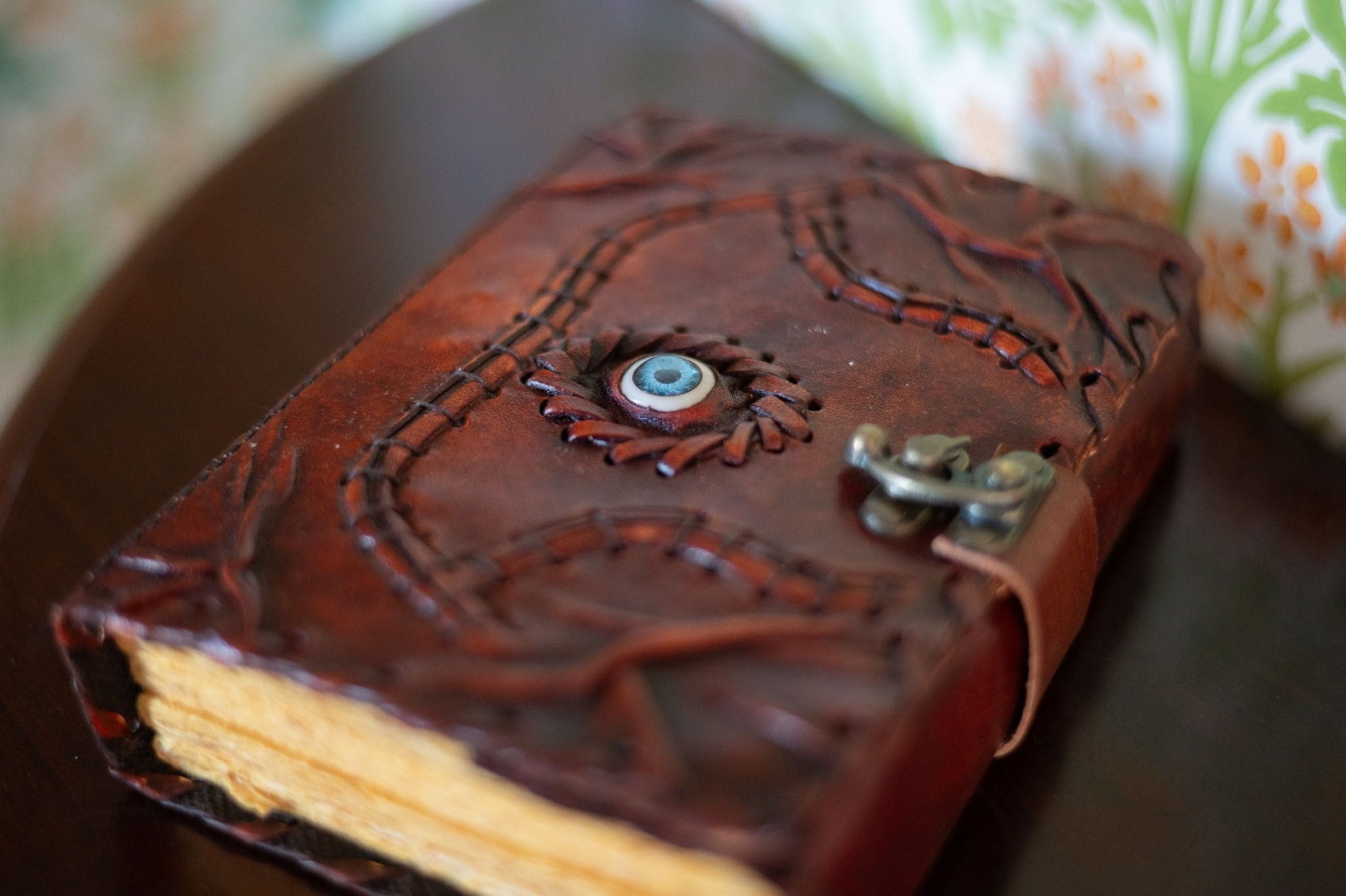 Un libro con encuadernación de cuero, cierre metálico y costuras decorativas.
