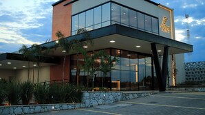Un hôtel moderne doté d’un toit plat, de grandes fenêtres en verre et d’une façade en pierre.