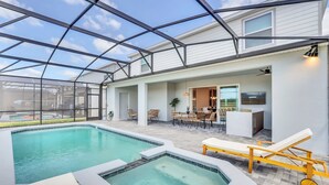 Un área de piscina con hidromasaje, sillas de descanso y un patio cubierto con zona de comedor.