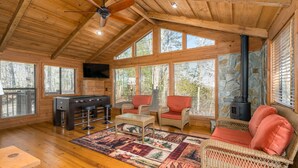 A cozy cabin interior with a wooden ceiling, a fireplace, a pool table, and wicker furniture. - Vista Cabin Getaway – Perfect Views + Dog Friendly (Blue Ridge)