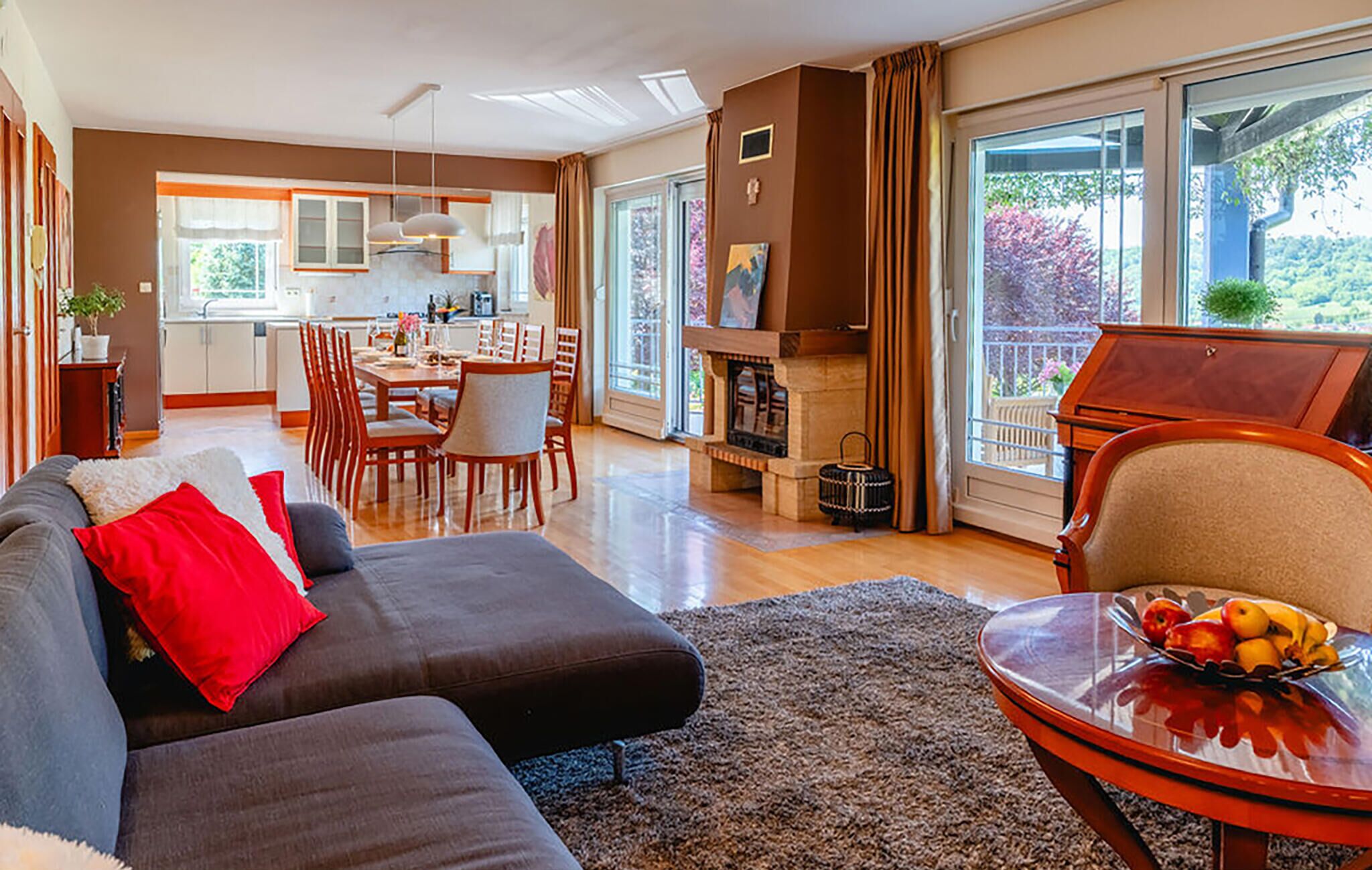 A modern living room with a sofa, a dining area, and a kitchen.