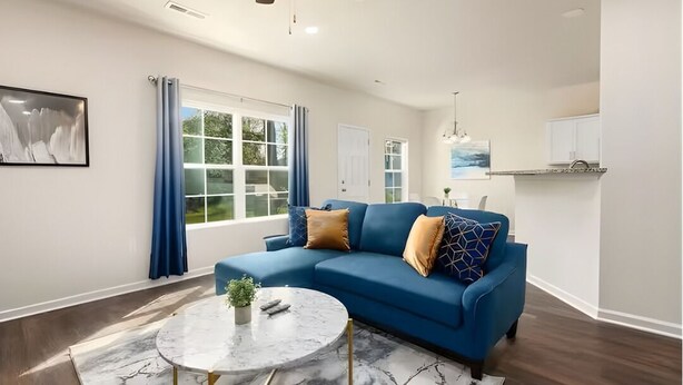 A living room with a blue sectional sofa, a marble coffee table, and a ceiling fan. - Southern Gem, Game Rm, Fire Pit, Near Coliseum (Greensboro)