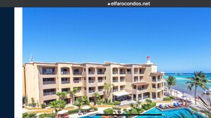 Un hotel con diversi balconi, piscina e vista sull'oceano.