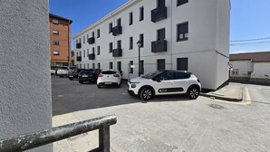 A multi-story building with a row of parked cars in front. - Perfecta UbicaciÓn Para Conocer Asturias (Oviedo)