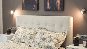 Een slaapkamer met een bed, nachtkastjes en twee schilderijen aan de muur.