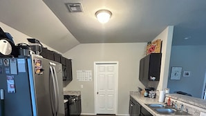 A kitchen with a refrigerator, stove, microwave, and sink.