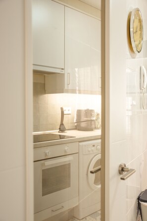 Eine Küche mit weißen Schränken, einer Mikrowelle, einem Backofen und einem Geschirrspüler.