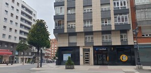 Un immeuble à plusieurs étages doté d’une façade moderne, d’une entrée bien visible et d’une devanture avec une enseigne.