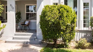 A single-story house with a white exterior, a covered porch, and a well-maintained front yard.