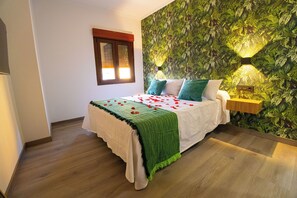 Una camera da letto con un letto, un comodino, una lampada a parete e una finestra con tende.