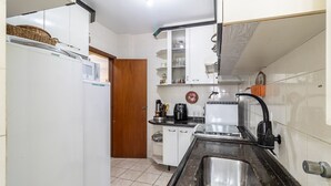 A compact kitchen with white cabinets, a microwave, a sink, and a stove. - 2 Bedroom apt 350m fr the Beach, BC Center Btr0302 (Balneário Camboriú)