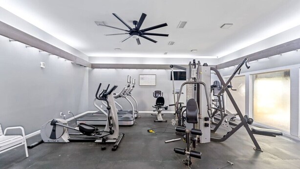 A gym with treadmills, elliptical machines, and weightlifting equipment.