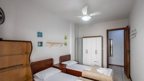 A hotel room with two beds, a wardrobe, a mirror, and a ceiling fan. - Apt w/ Balcony - Seafront in Meia Praia Ceo0104 (Itapema)