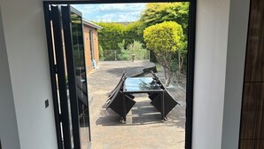 A doorway leading to a patio with a pool table and outdoor seating.