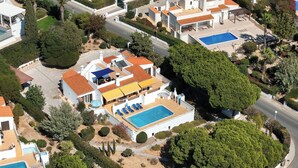 An aerial view of a residential area with multiple houses, each featuring a swimming pool and well-maintained gardens. - Casa Vale da Ana Carvoeiro with private pool (Carvoeiro)