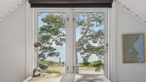 Une pièce avec vue sur la mer, une table, une lampe et une carte accrochée au mur.
