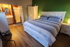 Een slaapkamer met een bed, nachtkastjes, een stoel en een kledingkast.