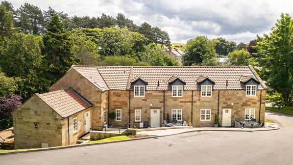 A stone building with a tiled roof, multiple windows, and a paved driveway. - Sag Harbour, Sandsend Retreats at Saltmoore - Sag Harbour (Sandsend)
