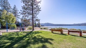 A park with a playground, benches, and a lake view. - Getaways at Lagonita Lodge (Big Bear Lake)