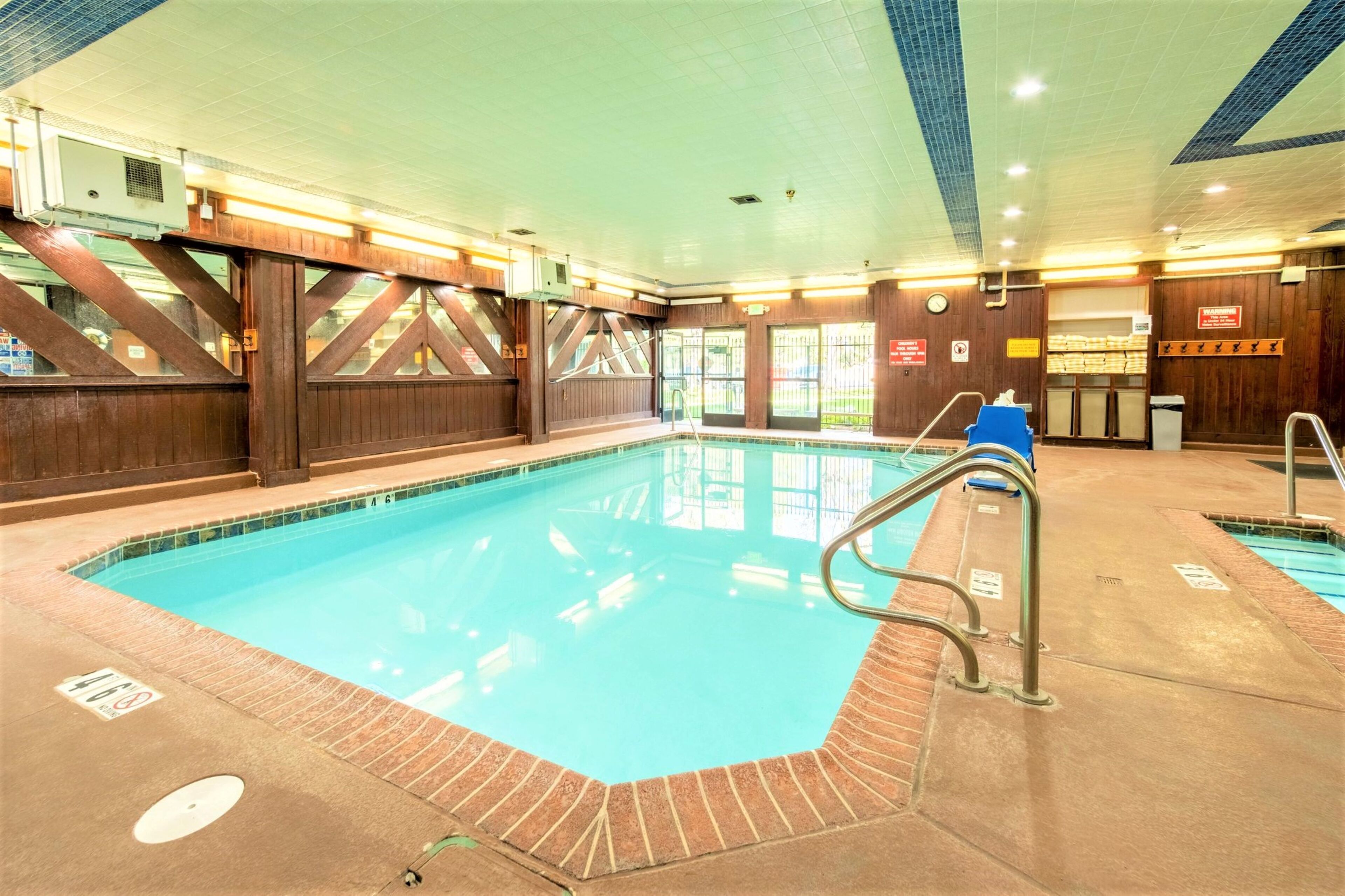 Une piscine intérieure avec des murs en bois et un plafond carrelé.