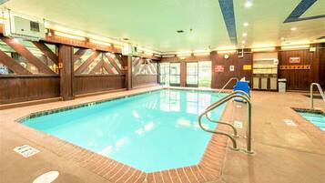 An indoor swimming pool with wooden walls and a tiled ceiling.