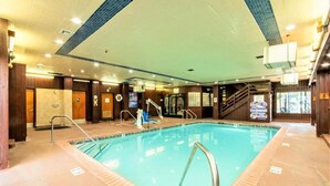 An indoor swimming pool with a tiled floor, a metal ladder, and a staircase leading to an upper level. - Getaways at Lagonita Lodge (Big Bear Lake)