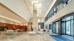 Un hall d’entrée spacieux, doté d’un sol en marbre, de coins salon et de grandes fenêtres offrant une vue panoramique.