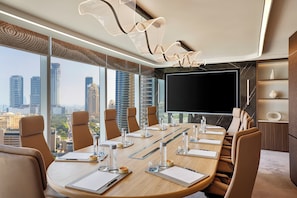 A conference room with a large table, chairs, a flat-screen TV, and a city view. - Ciel Dubai Marina, Vignette Collection by IHG (Dubai)