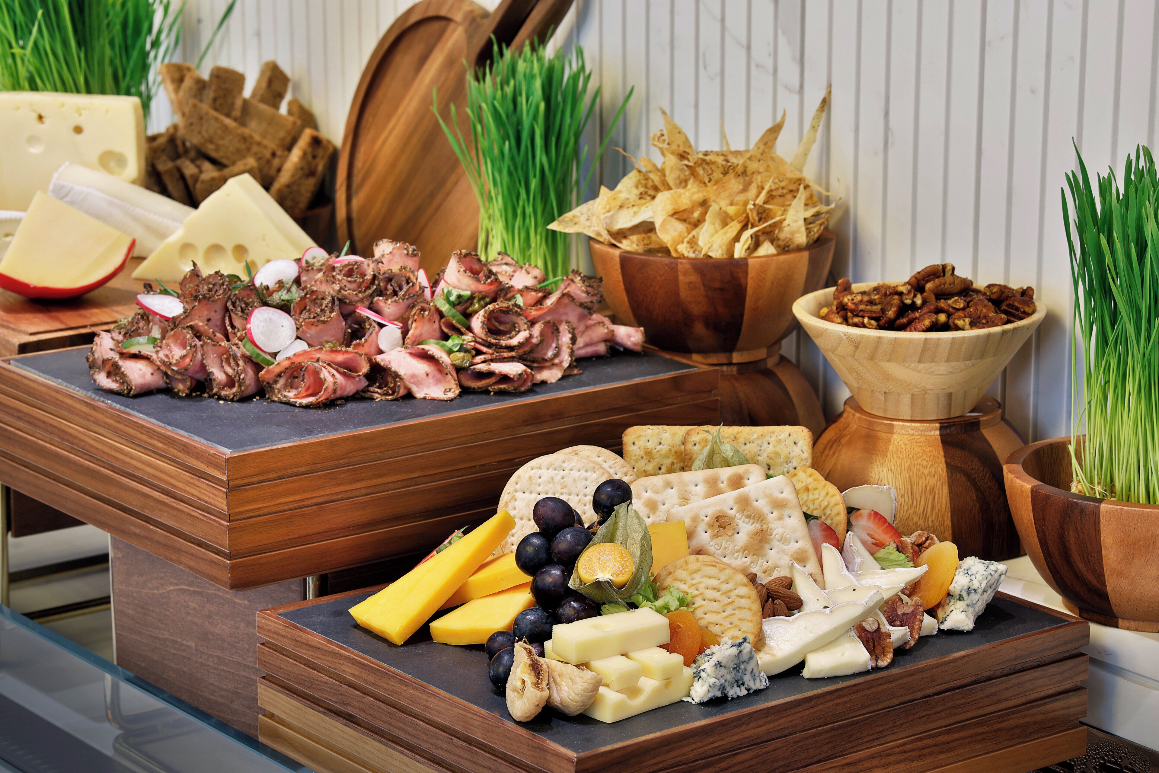 A charcuterie board with various cheeses, meats, crackers, and fruits.