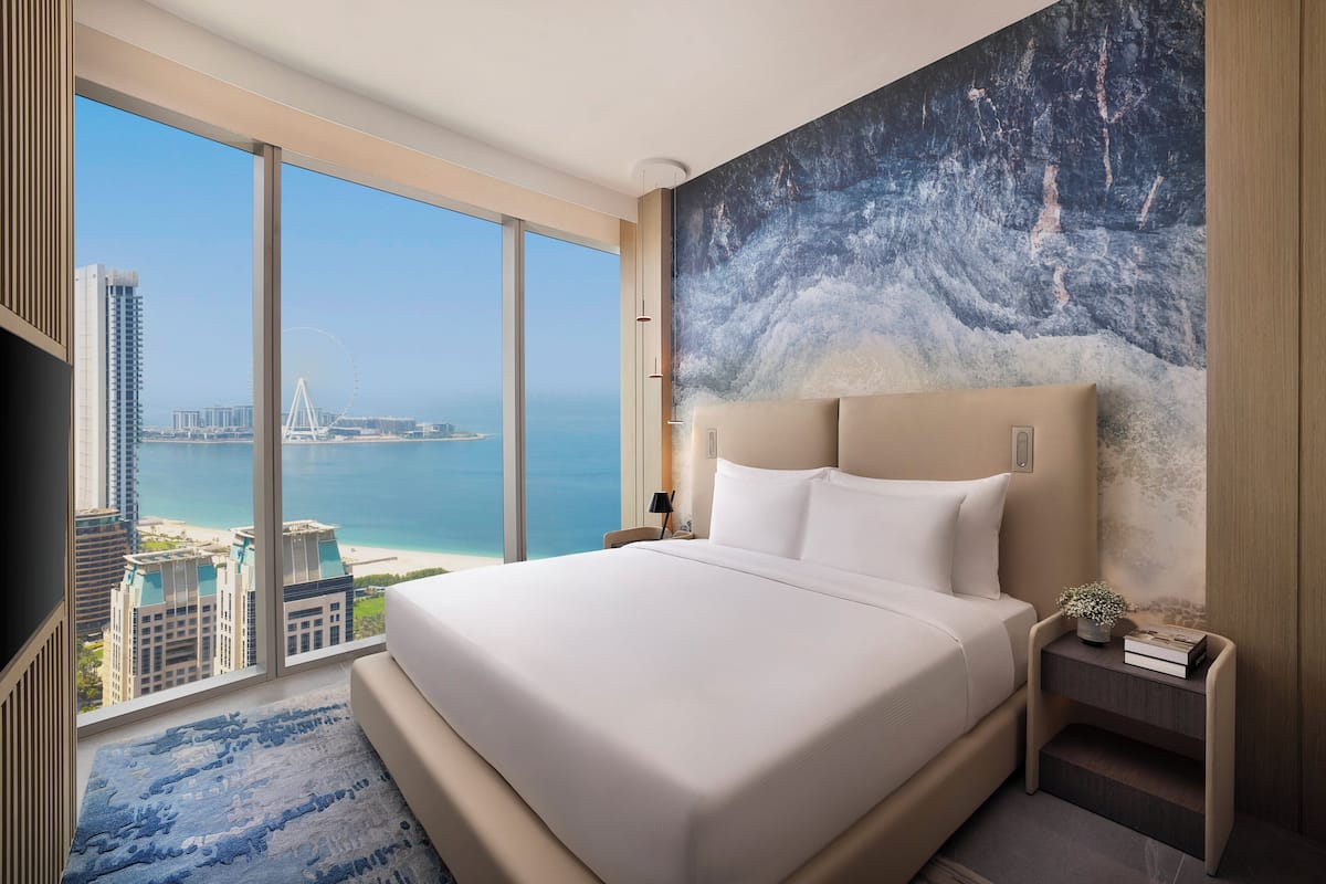 A large bed with a view of the city and sea.