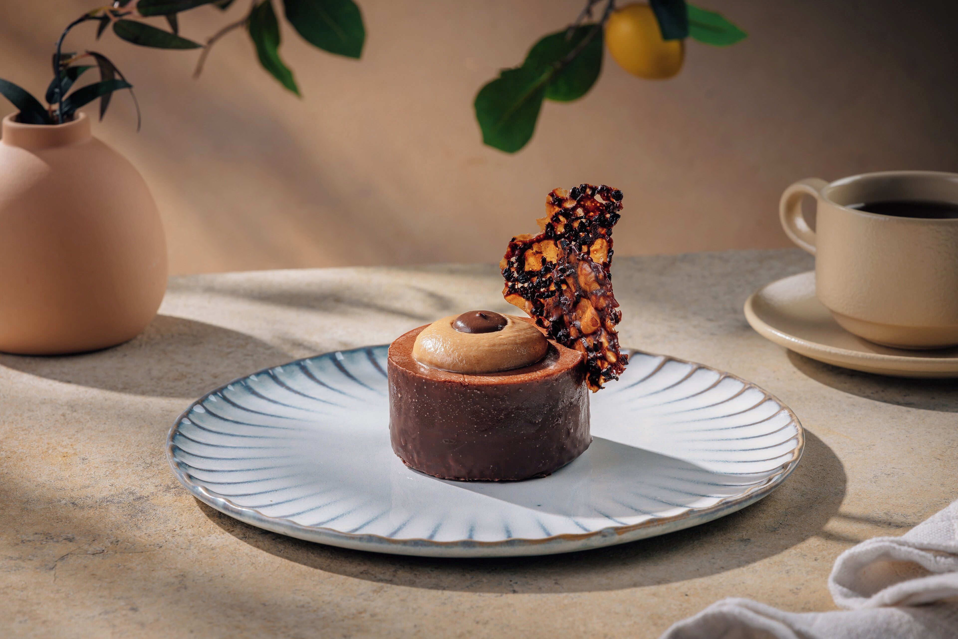 Een dessert op een bord, met een kop en schotel ernaast.