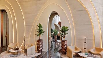 A modern lobby with arched ceilings, marble flooring, and contemporary furniture.