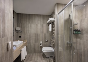 Un baño moderno con inodoro, lavabo y ducha.