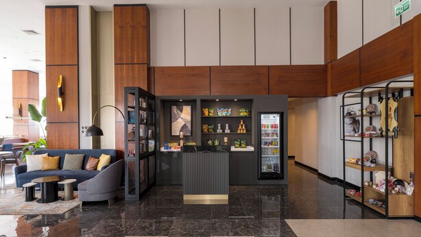 Una hall moderna con un'area salotto, una macchina distributrice e un espositore di snack.