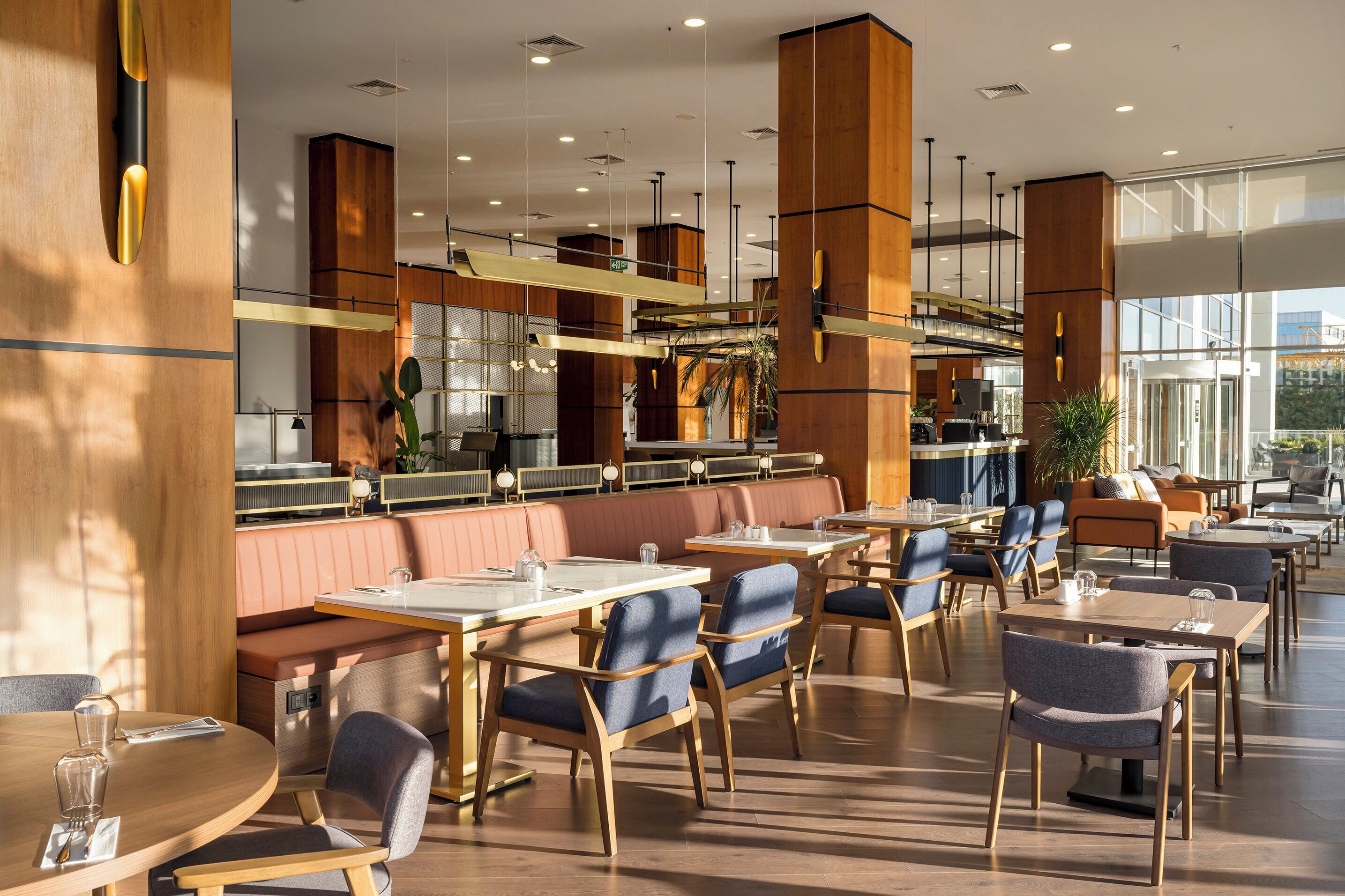 A modern restaurant with wooden accents, high tables, and comfortable seating.