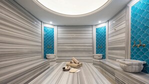 Une salle de bain avec un sol en marbre, une grande baignoire et un mur recouvert de carreaux bleus.