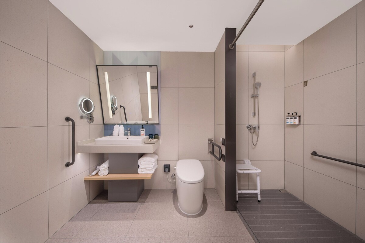 A modern bathroom with a toilet, sink, and shower.