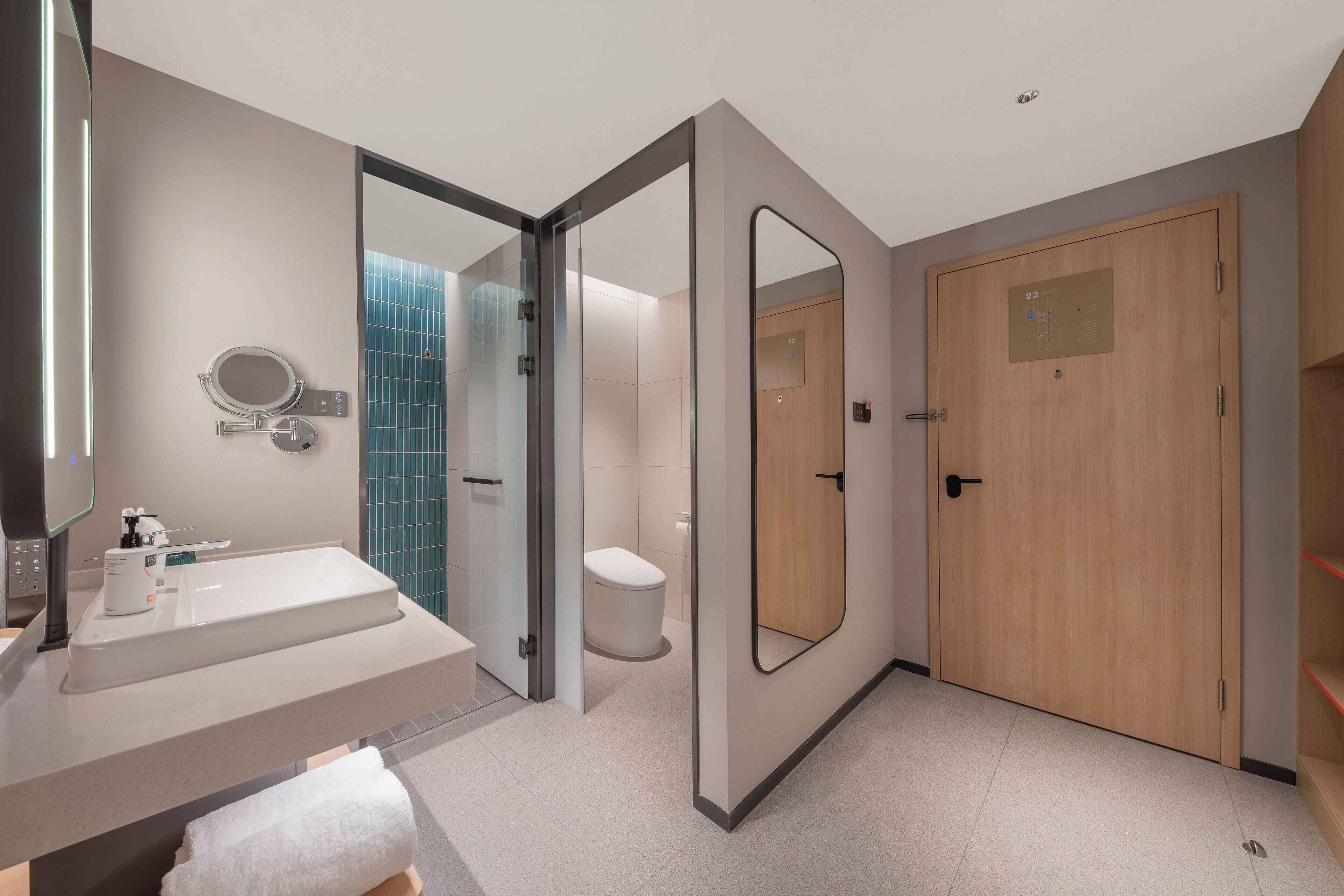 Ein modernes Badezimmer mit Duschkabine aus Glas, Toilette und Waschbecken mit Spiegel.