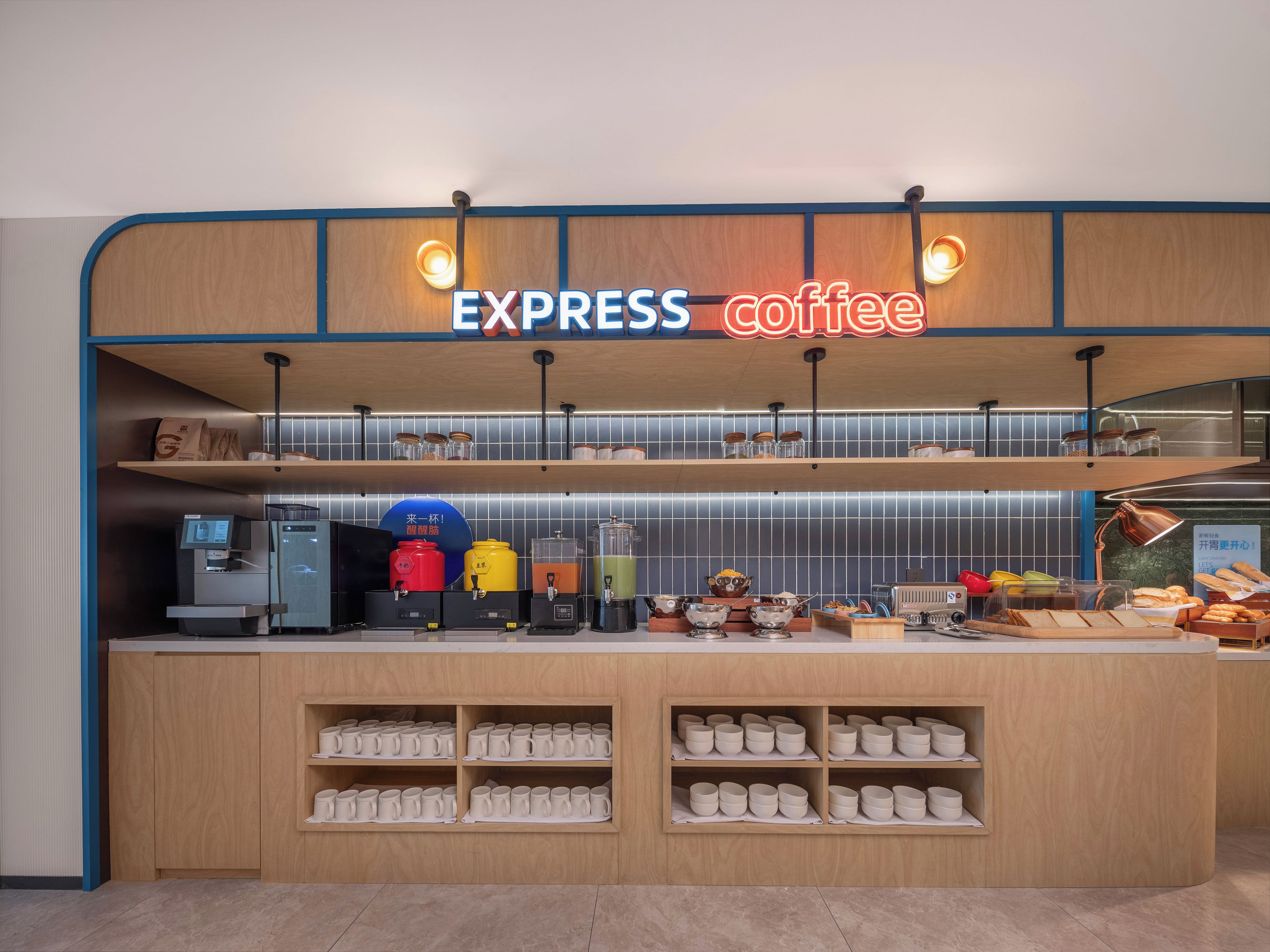 A coffee shop interior with a wooden counter, coffee machines, and shelves of cups.