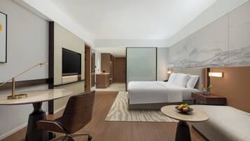 Une chambre d’hôtel moderne équipée d’un lit, d’un bureau, d’une chaise et ornée d’une grande fresque murale.