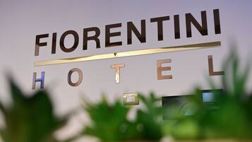 Segnaletica dell'Hotel Fiorentini, dal design moderno, con una linea orizzontale sopra la parola 'HOTEL'.