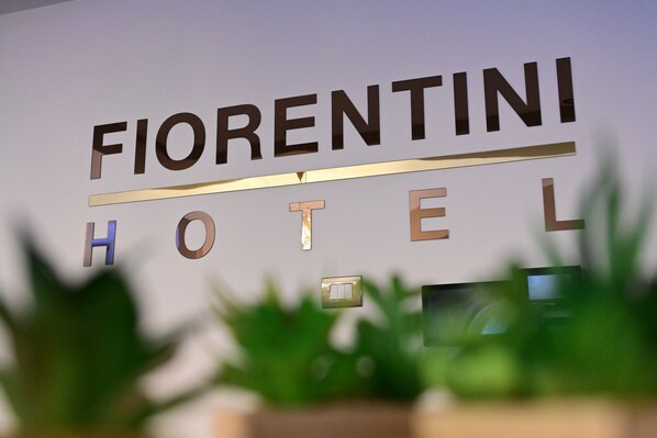 Letrero del Hotel Fiorentini con diseño moderno y una línea horizontal sobre la palabra 'HOTEL'.