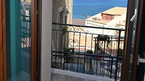 Un balcón con vista al mar y edificios.