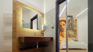 Un baño moderno con tocador de madera, un espejo grande y un salpicadero de mármol.