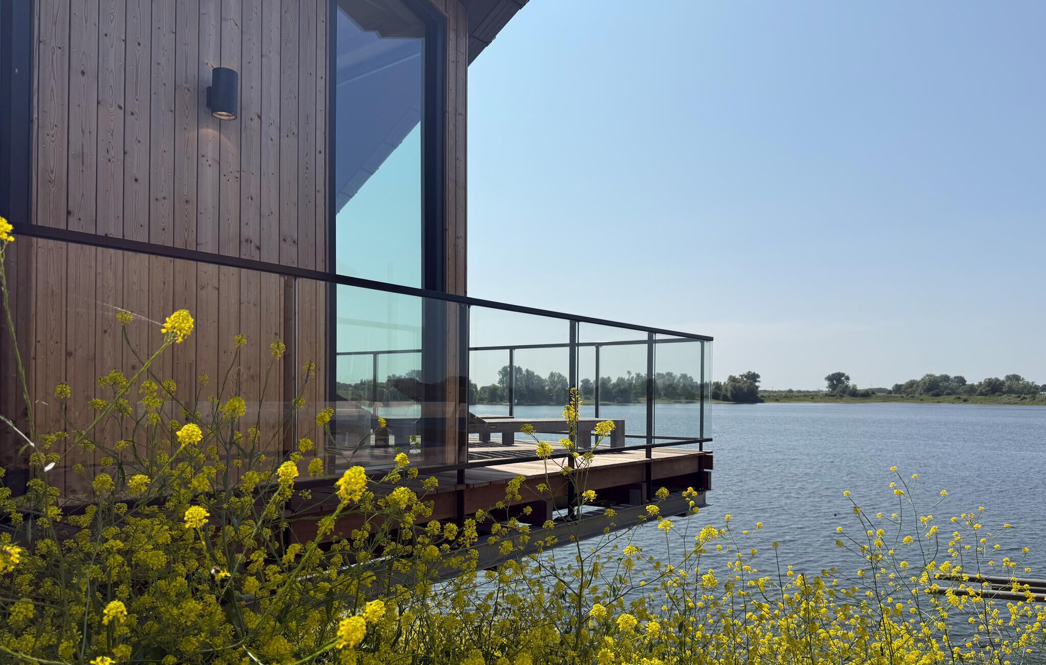 A modern building with a glass facade overlooking a body of water.